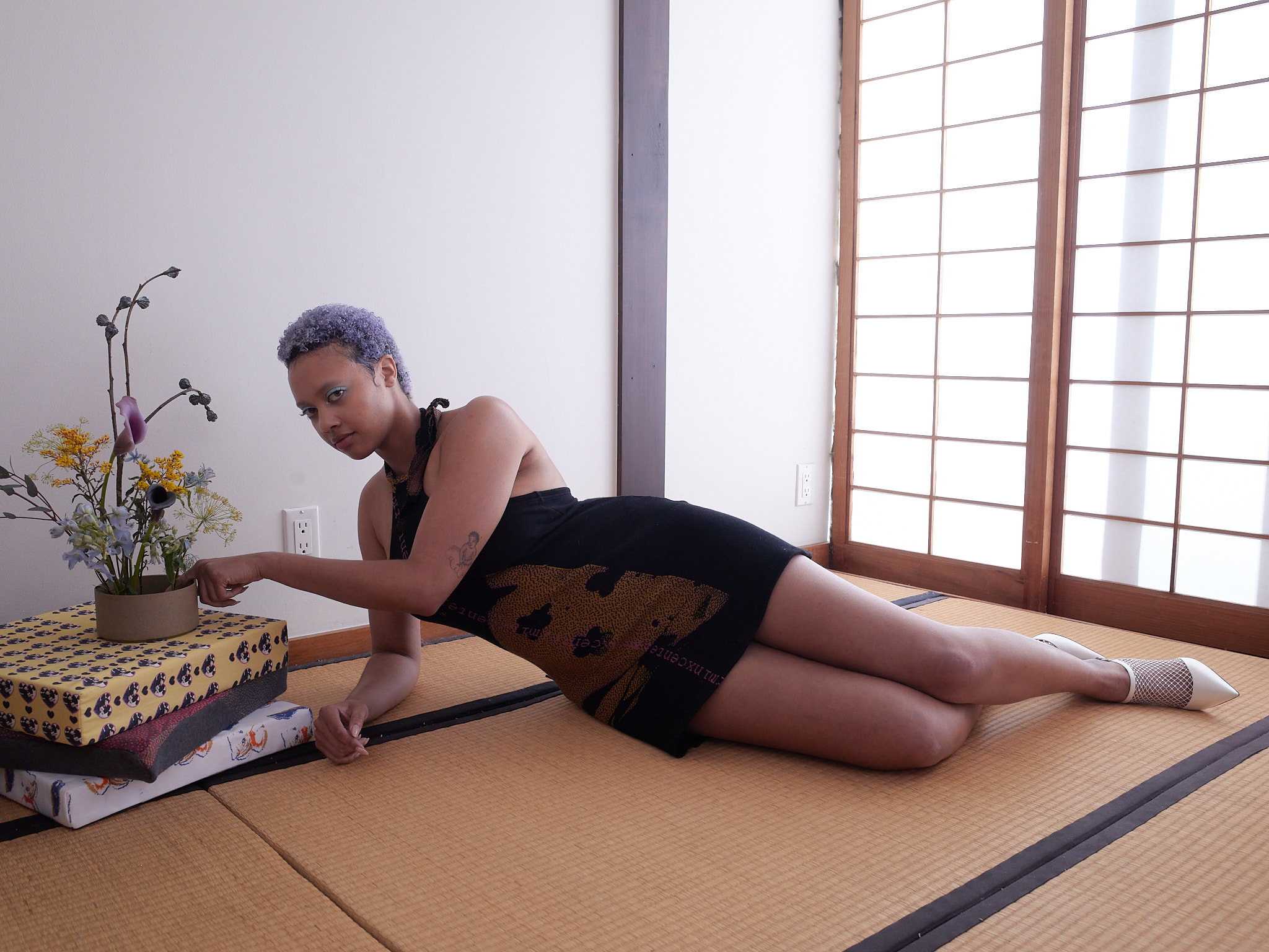 DJ Miss Parker getting their makeup done by Jesse Clark, looking up at Jesse while eyeshadow is applied